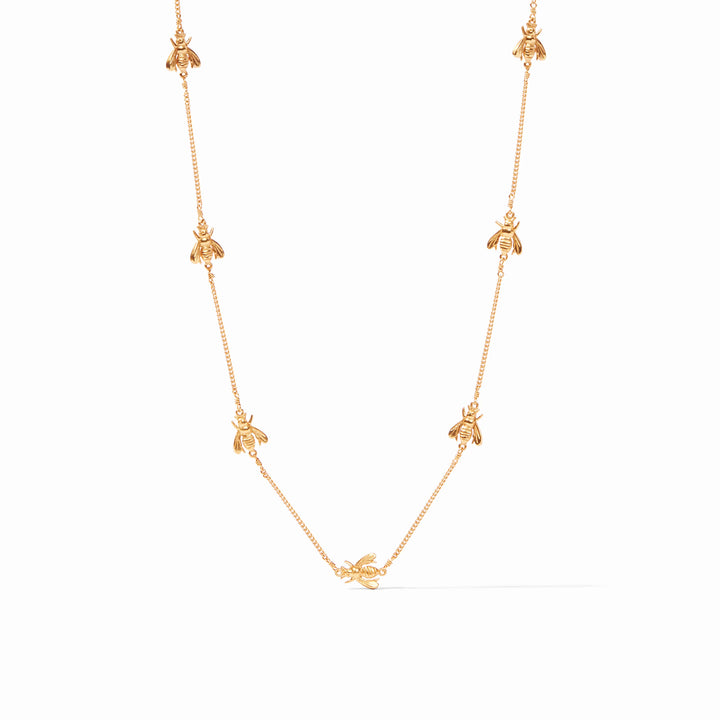 Gold necklace with bee charms on a white background