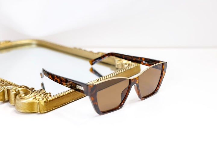Sunglasses with gold frame and tortoiseshell frame on a white background