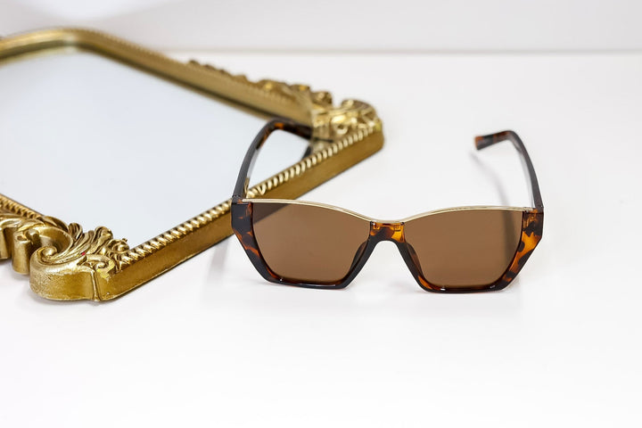 Sunglasses with a gold frame on a white surface