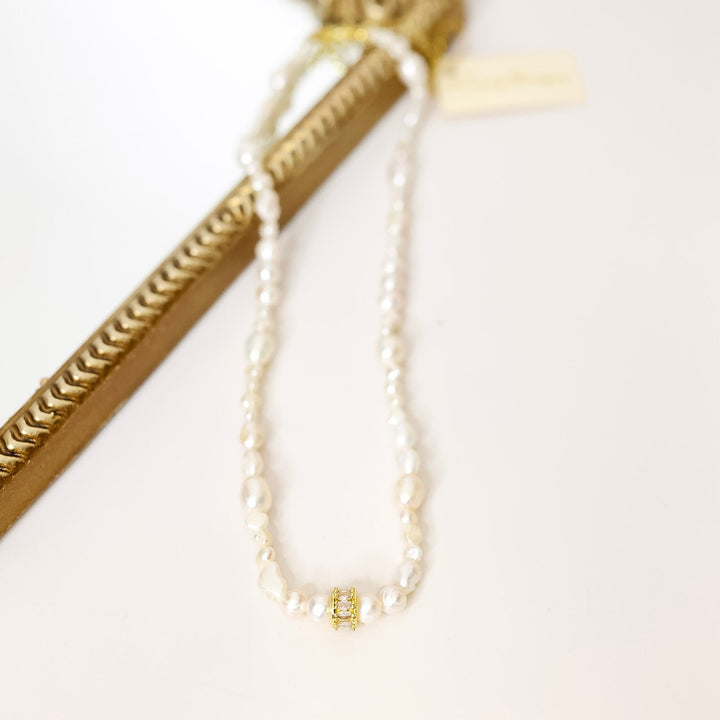 Gold pearl necklace with a gold frame on a white background