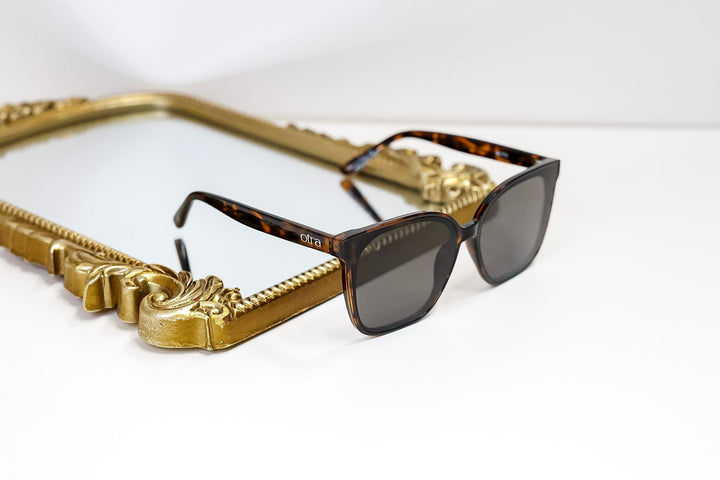 Sunglasses with a decorative gold frame on a white background