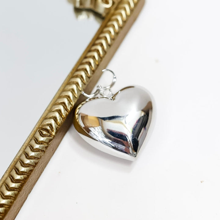 Silver heart-shaped pendant on a white background