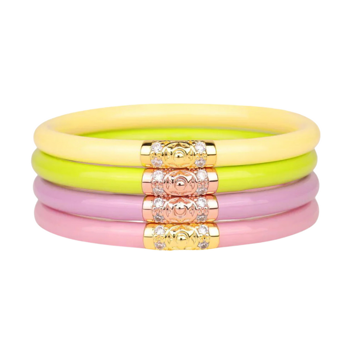 A stack of 4 bracelets perfect for springtime! Each bracelet is made up of flexible tubing and has a metal segment with crystals. (Top to Bottom) Yellow, Green, Purple, and Pink.