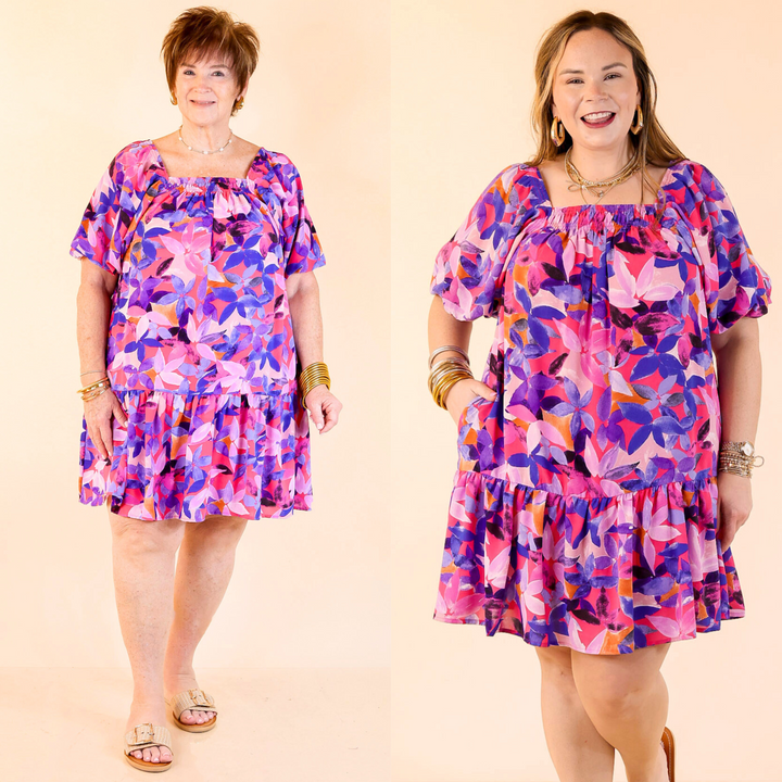 Magenta dress featuring intricate purple and blue blooms! With puffed sleeves, a square neckline and a tiered style. Available in sizes small through plus size.