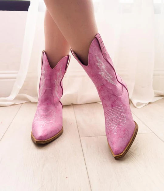 Pink cowboy boots on a light background