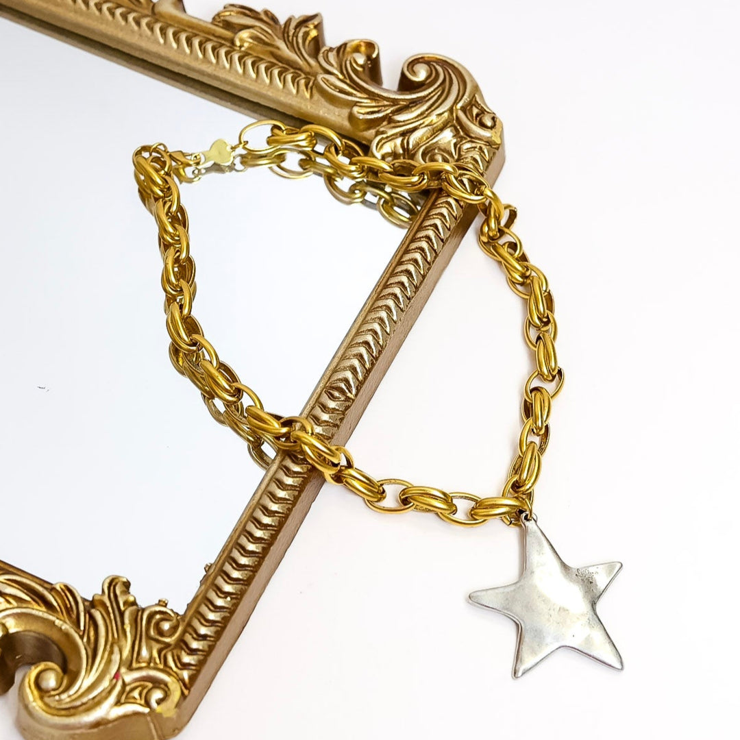 Gold chain with a star pendant on a white background