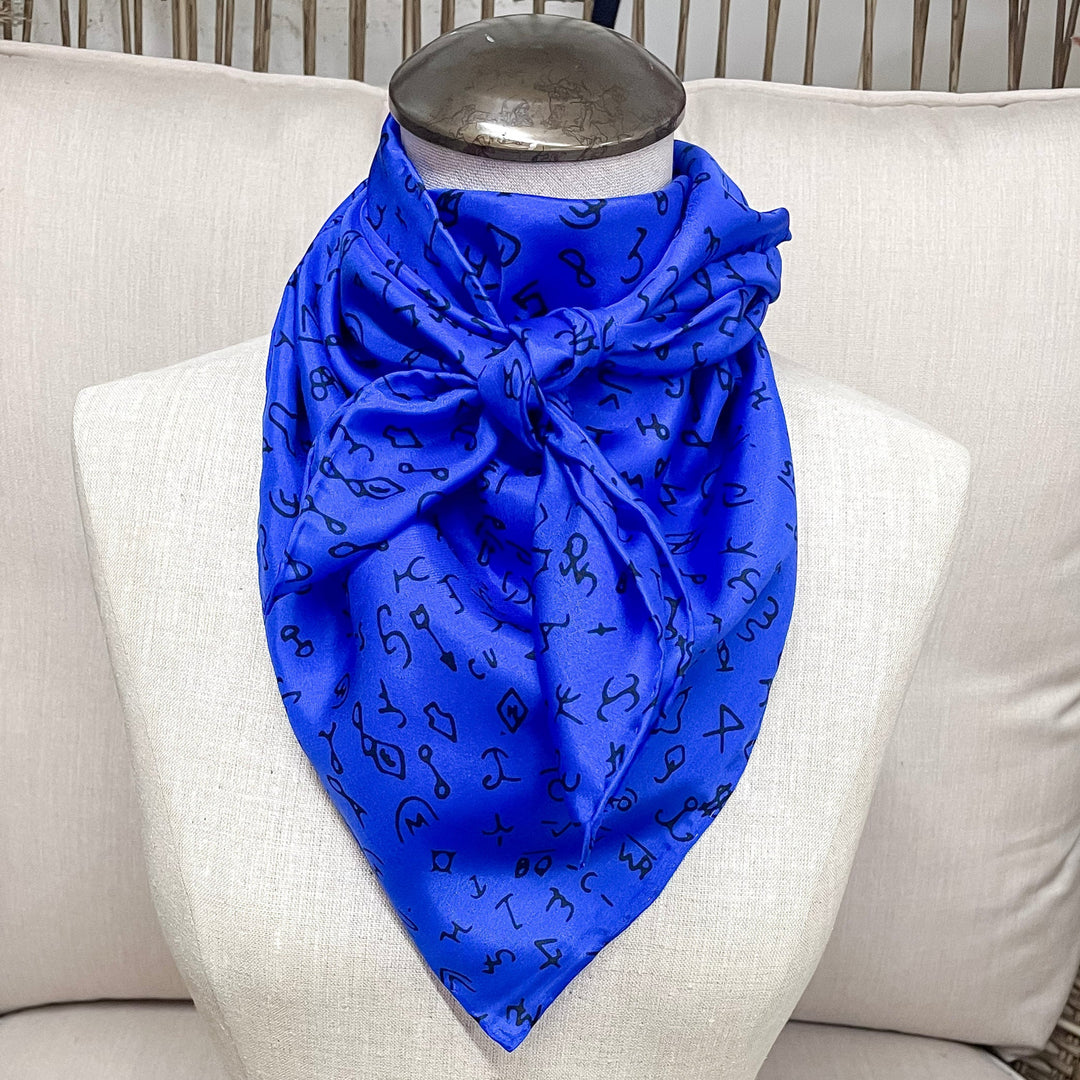 A royal blue wild rag thats branded and is tied around a mannequin neck.