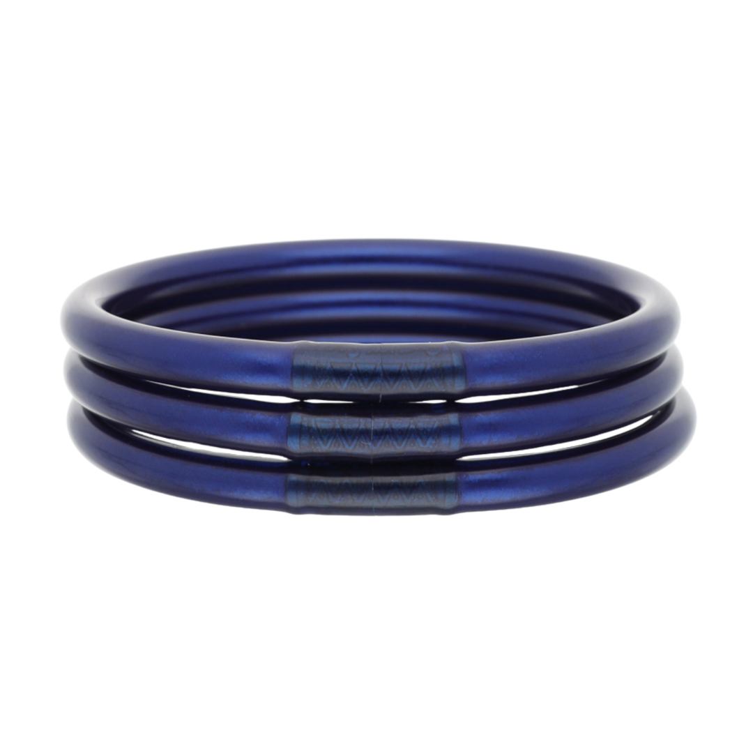 A stack of three metallic blue bangles or bracelets with a textured center band, shown on a plain white background.