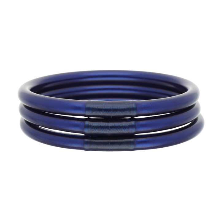 A stack of three metallic blue bangles or bracelets with a textured center band, shown on a plain white background.
