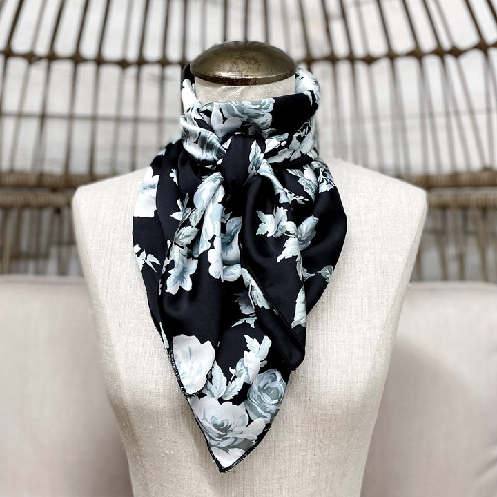 Mannequin head with a black and white floral scarf on a wicker chair