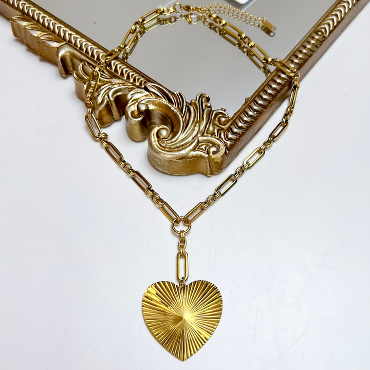 CHANSUTT PEARLS Haven Heart Pendant Necklace in Gold featuring an elongated paperclip chain and oversized textured heart pendant with a sunburst design.