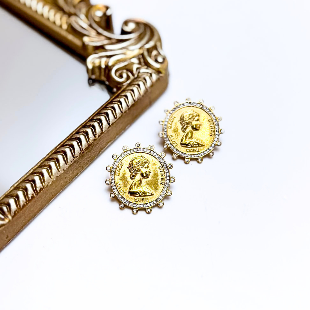 Gold earrings with a decorative frame on a white background