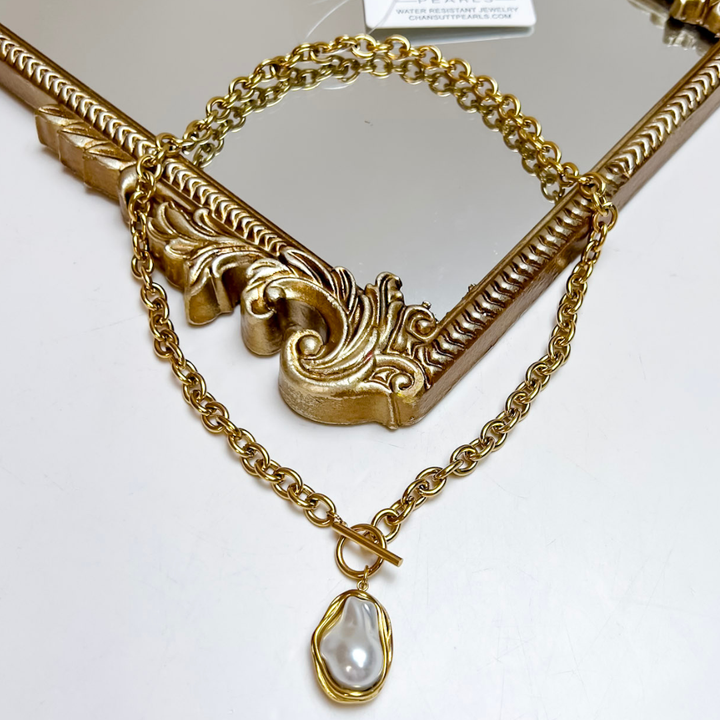 CHANSUTT PEARLS Pearl Drop Statement Necklace in Gold featuring an oval link chain, front toggle closure, and organic-shaped pearl pendant framed in gold.