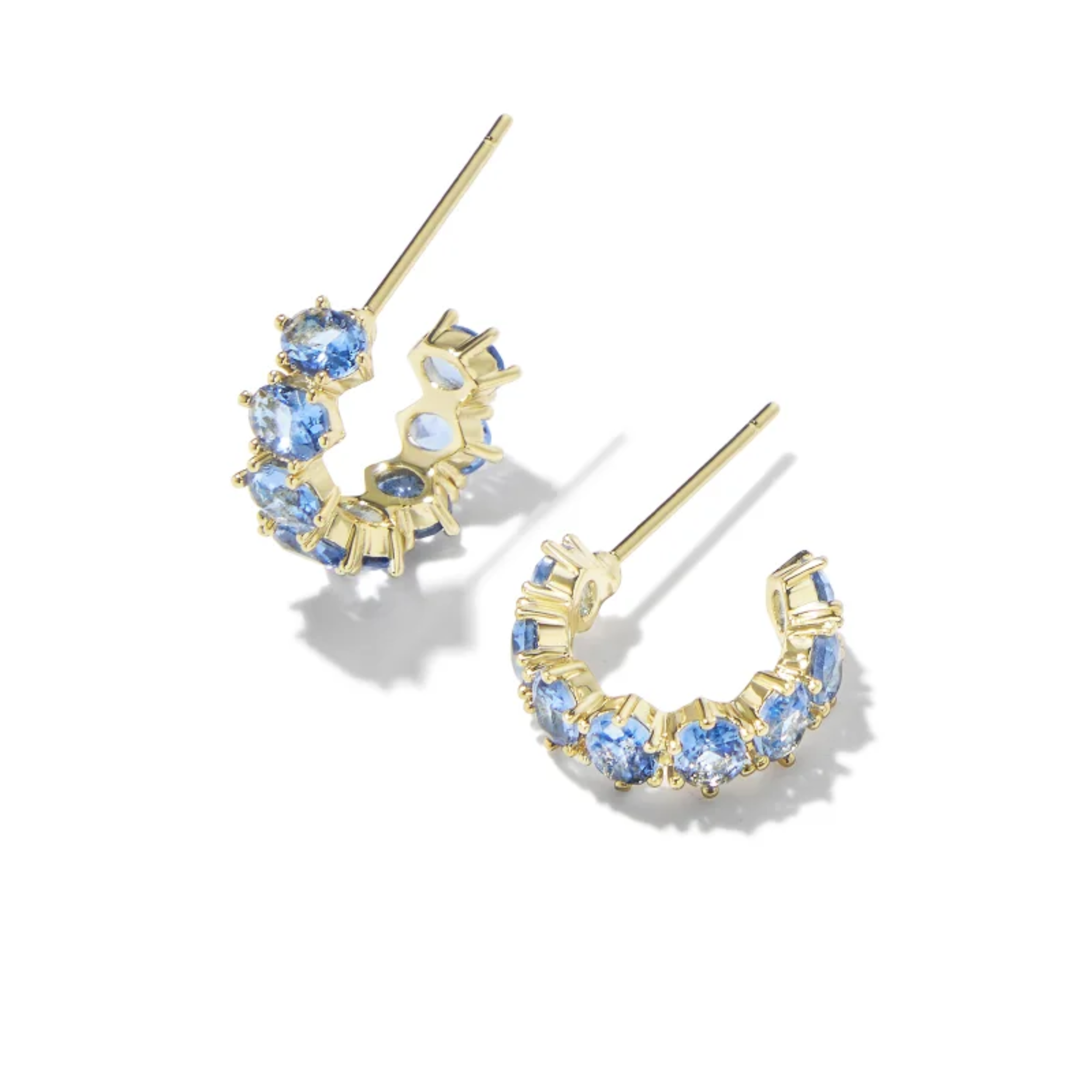 These Cailin Gold Crystal Huggie Earrings in Blue Violet Crystal by Kendra Scott are pictured on a white background.