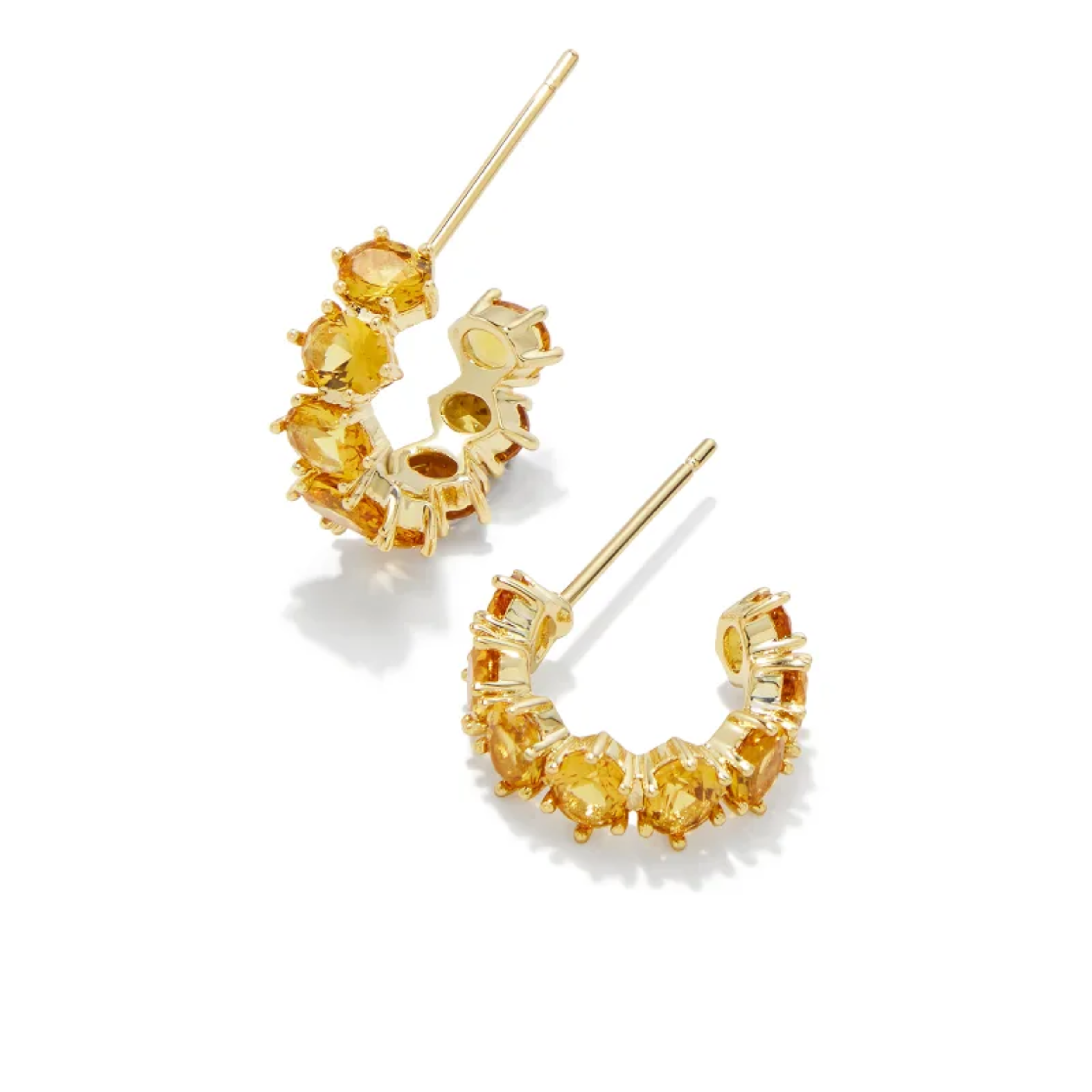 These Cailin Gold Crystal Huggie Earrings in Golden Yellow by Kendra Scott are pictured on a white background.