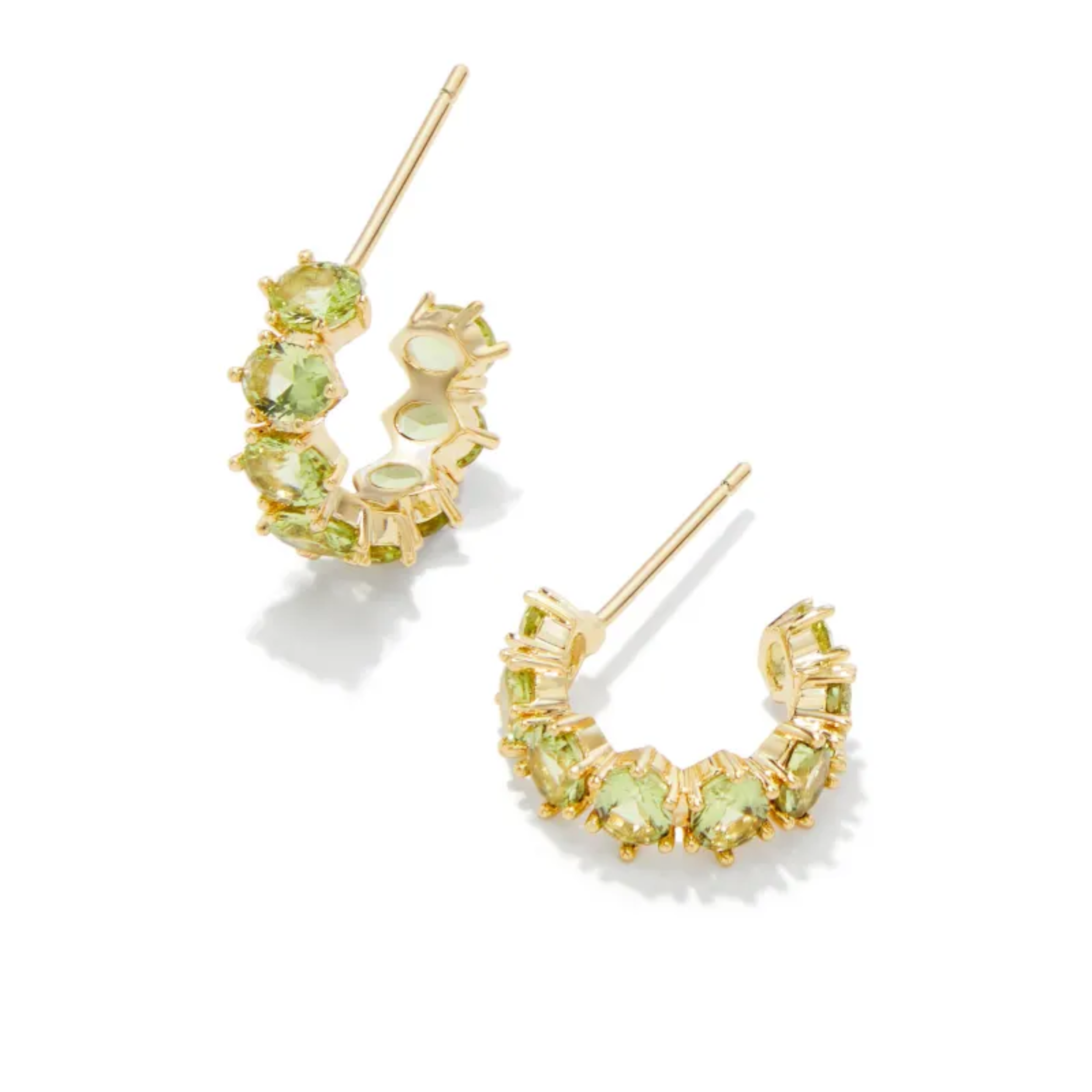 These Cailin Gold Crystal Huggie earrings in Green Peridot Crystal by Kendra Scott are pictured on a white background.