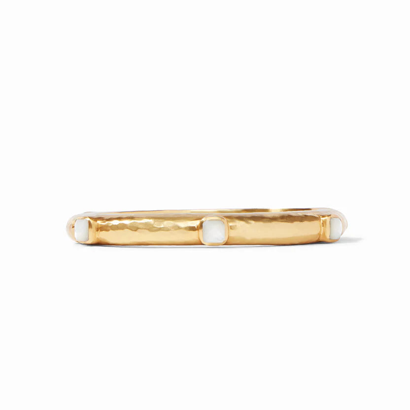 Pictured is a gold, hammered bracelet with ivory mother of pearl stones spaced out. This bracelet is pictured on a white background. 