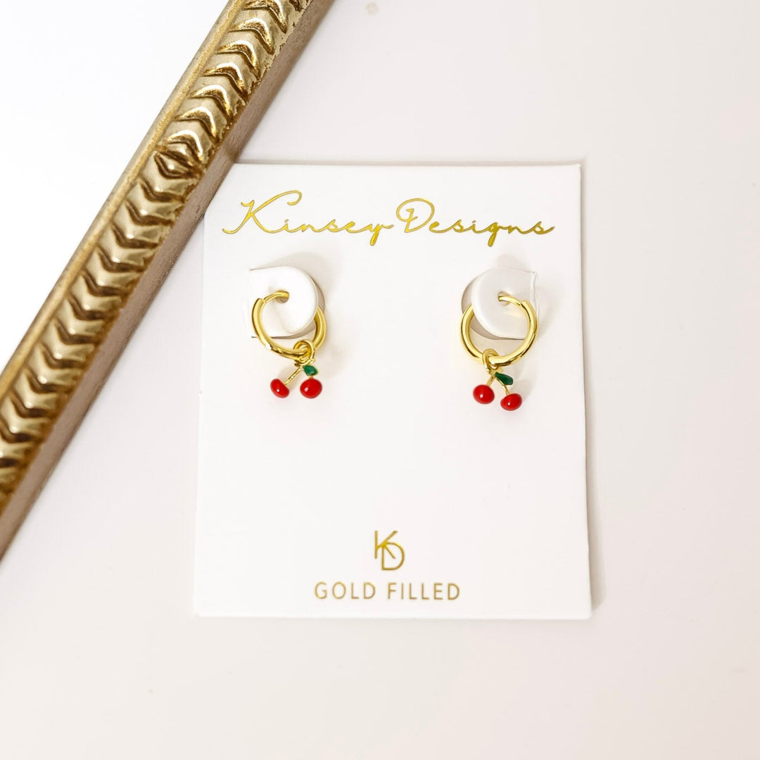 Gold earrings on a Kinsey Designs card with a decorative gold frame.