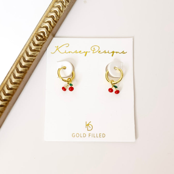 Gold earrings on a Kinsey Designs card with a decorative gold frame.
