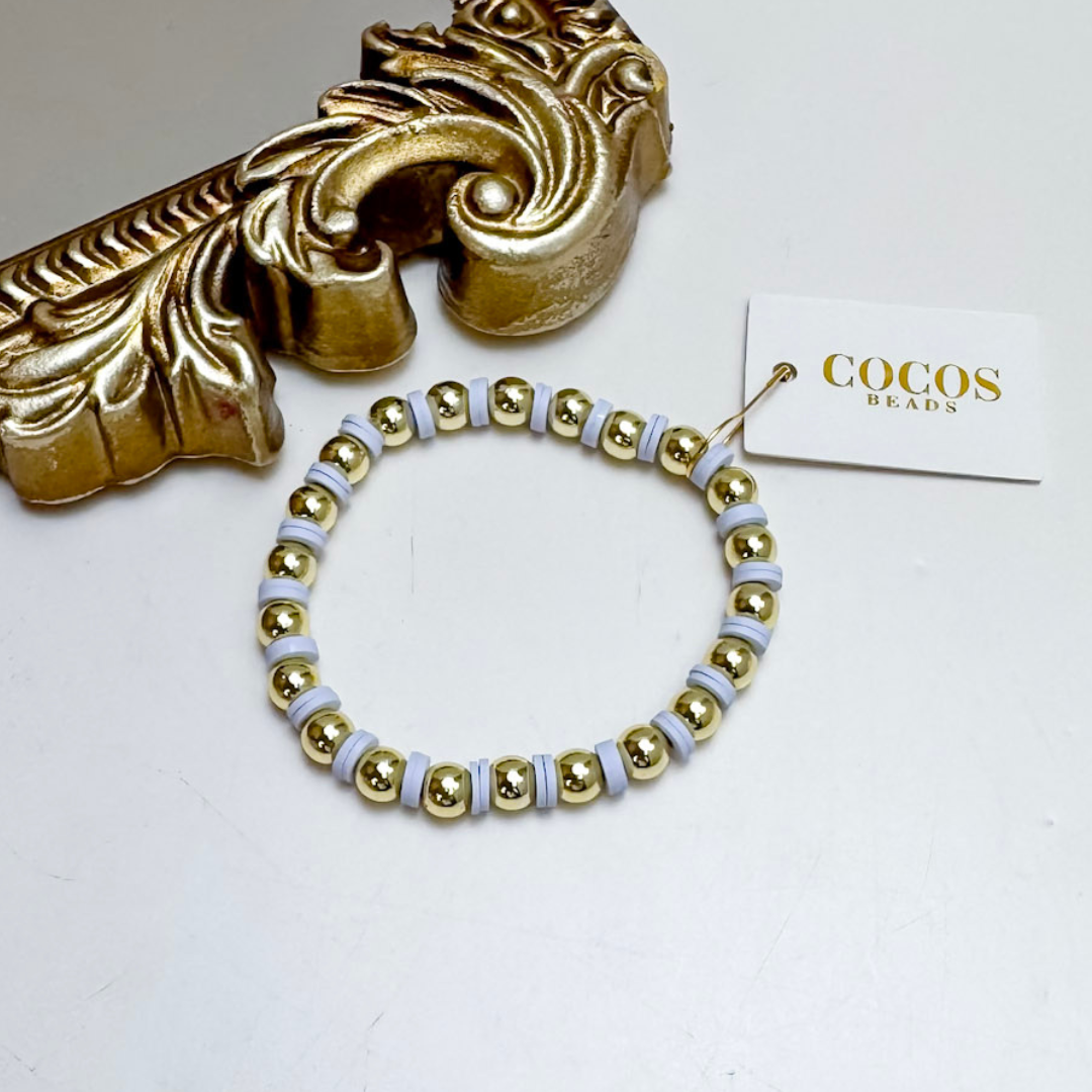 Gold and white beaded bracelet with decorative gold object and &