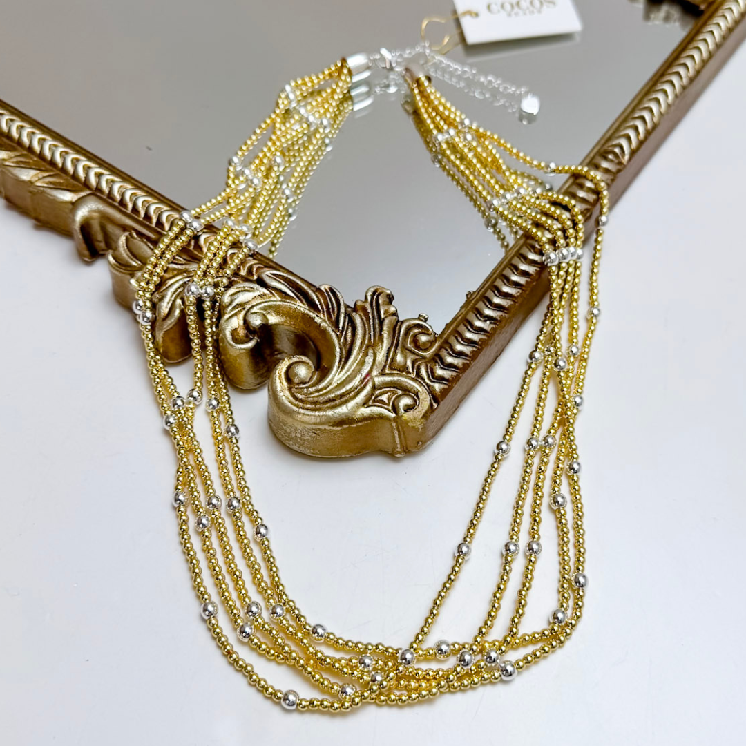 Layered gold necklace on white background.