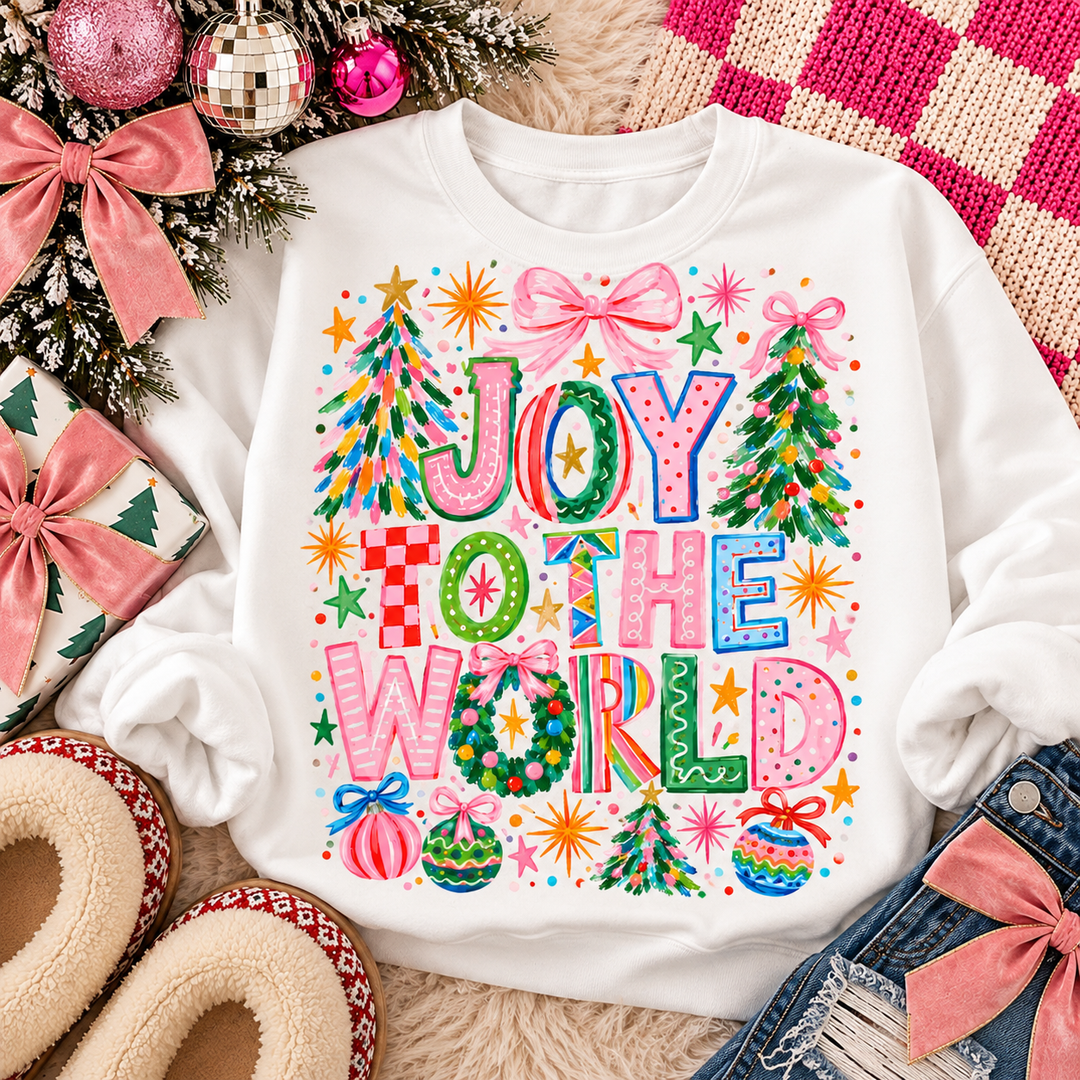 Colorful Joy To The World Christmas graphic tee or sweatshirt on white with whimsical Joy to the World lettering with trees, bows and ornaments