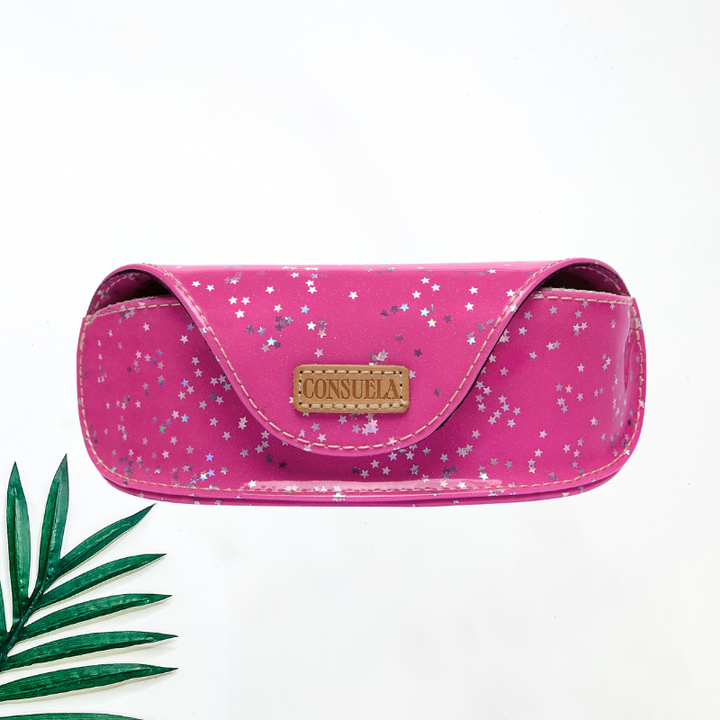 A bright pink Consuela eyeglasses case with a silver and white star glitter pattern and a tan leather brand patch.