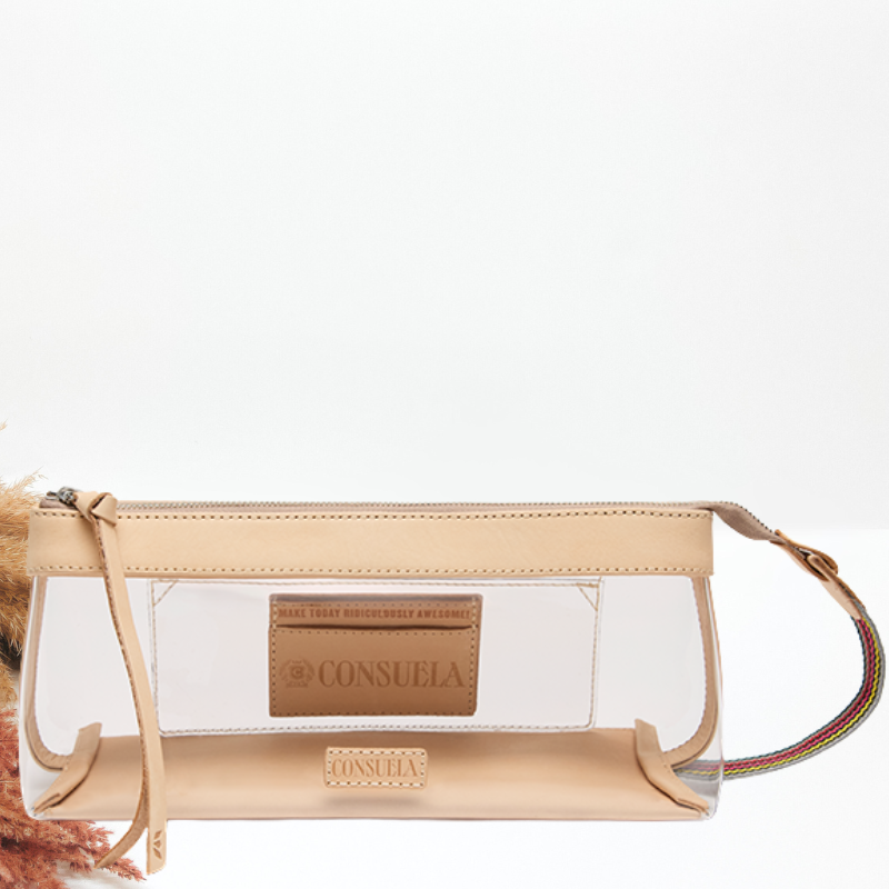 A clear plastic and beige faux-leather pouch bag with a zippered top, a tan brand patch on the front, and a thin multicolor striped strap, shown against a plain white background.