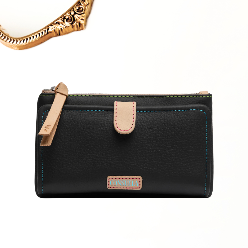 A black pebbled leather wallet with tan leather accents, a wrist strap and front tab, light blue contrast stitching, and a Consuela leather brand plate.