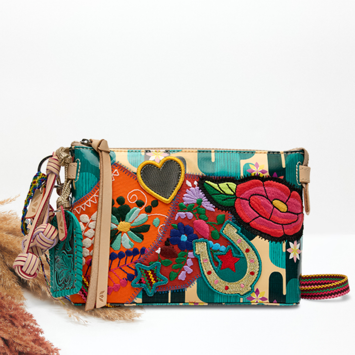 Colorful handbag with floral and abstract patterns on a white background