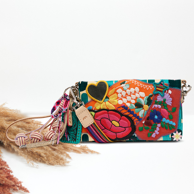 Colorful embroidered clutch bag with tassels on a white background