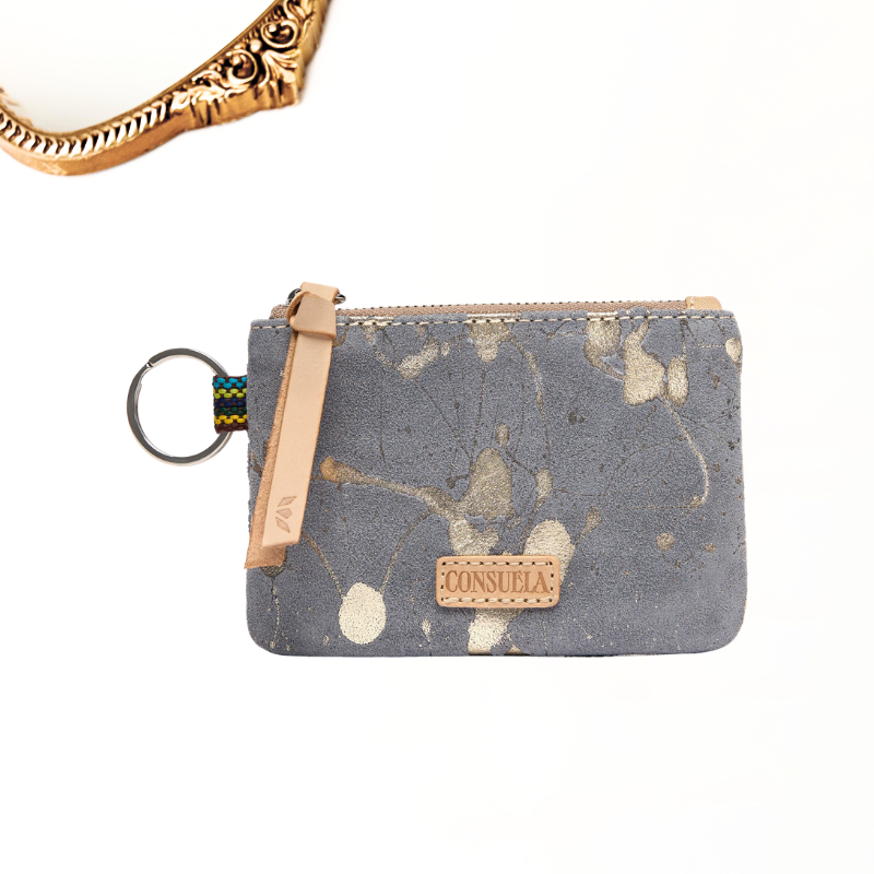 A small zippered pouch with a gray marbled pattern, a tan leather wrist strap, and a metal key ring, shown on a white background with a partial gold bracelet at the top.