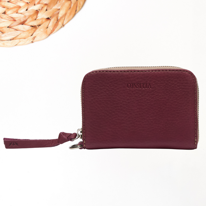 Maroon wallet with brand name on a white background
