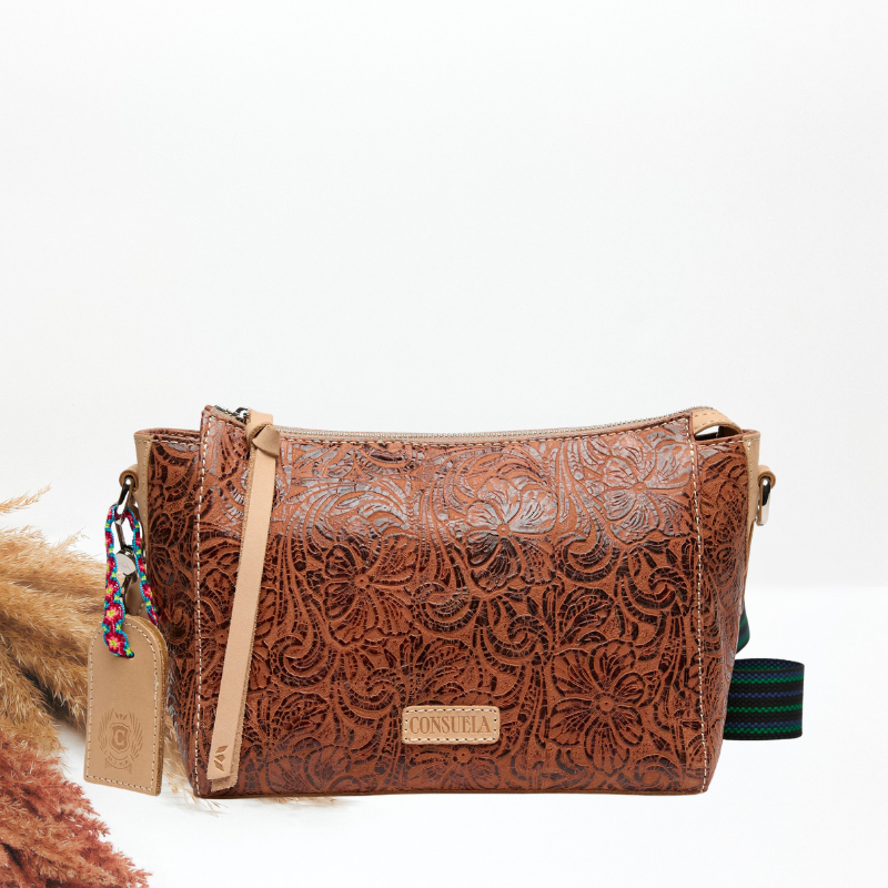Brown leather handbag with floral patterns on a white background