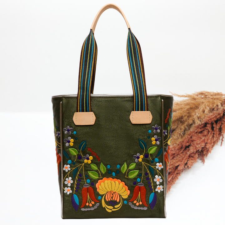 Green tote bag with colorful floral embroidery on a white background