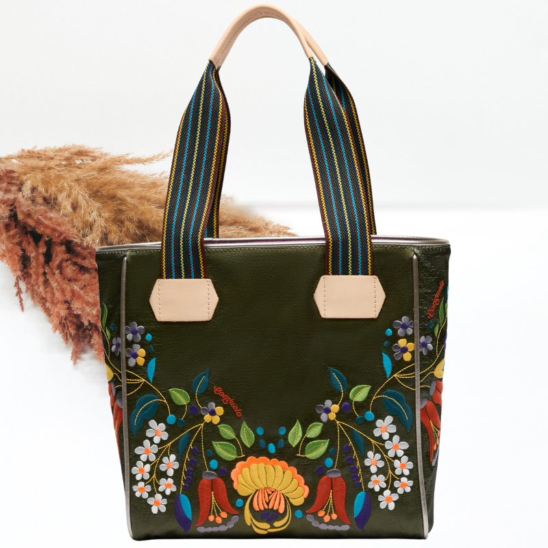 Green handbag with floral embroidery and striped handles on a white background