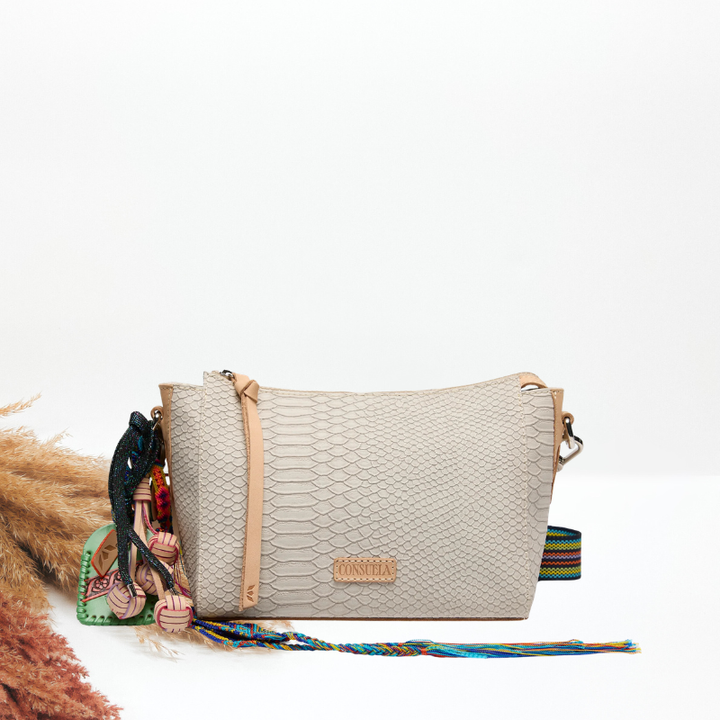 Beige textured handbag with colorful strap on a white background
