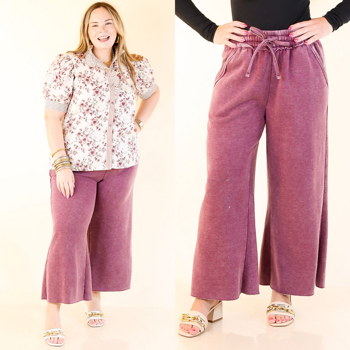 Woman wearing a floral shirt and purple pants with a close-up of the pants on a plain background.