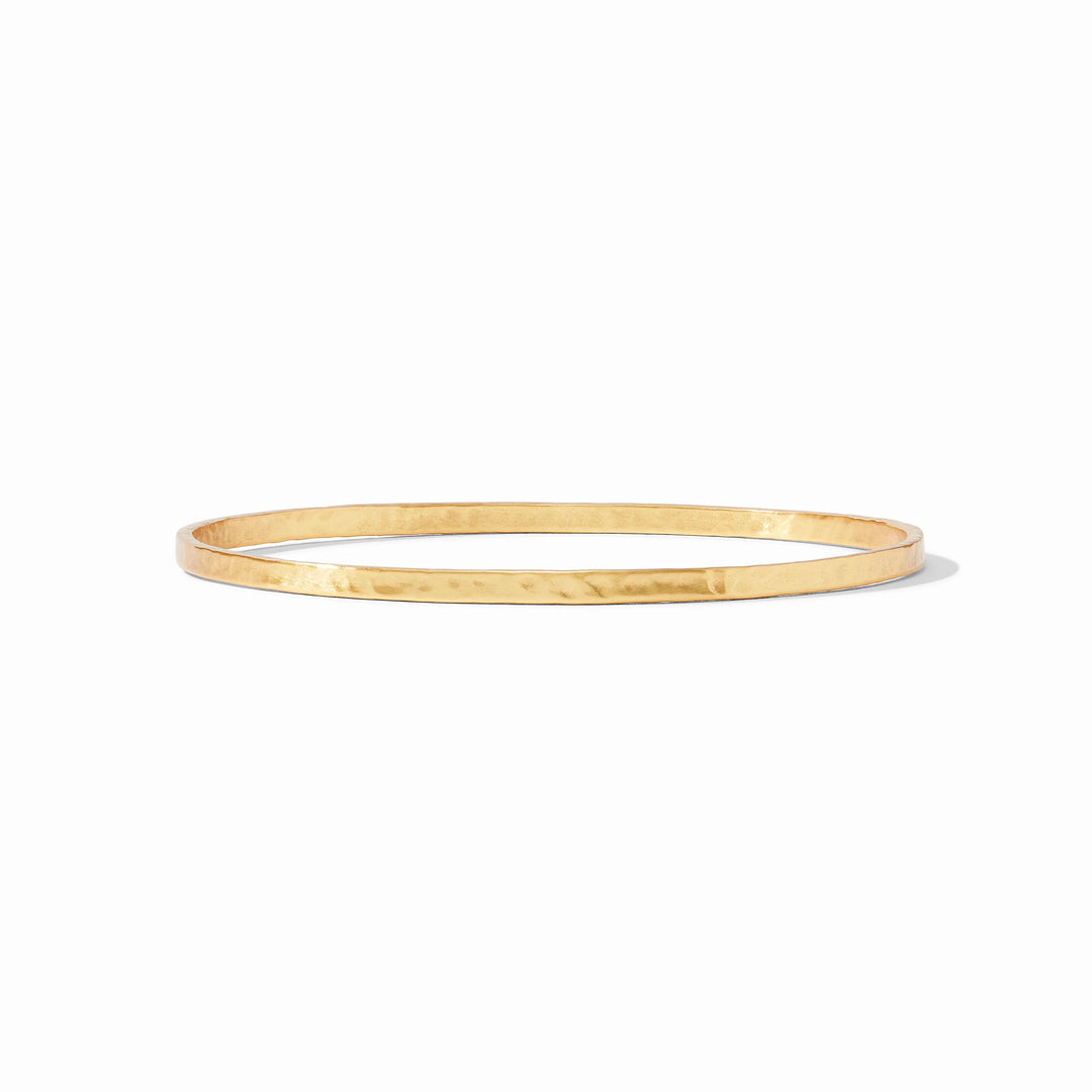 Gold hammered bangle on a white background