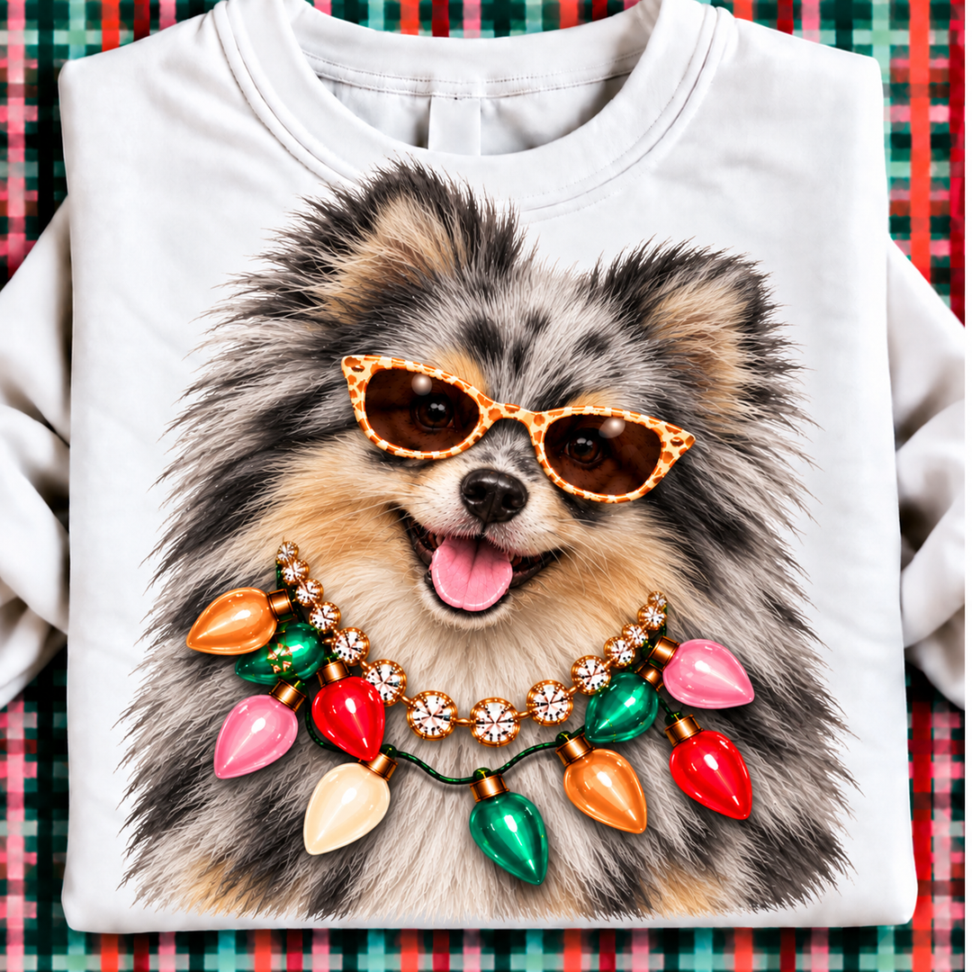 Holiday Boujee Blue Merle Pomeranian Christmas graphic tee or sweatshirt on white with a blue merle Pomeranian in sunglasses, a crystal necklace and Christmas lights
