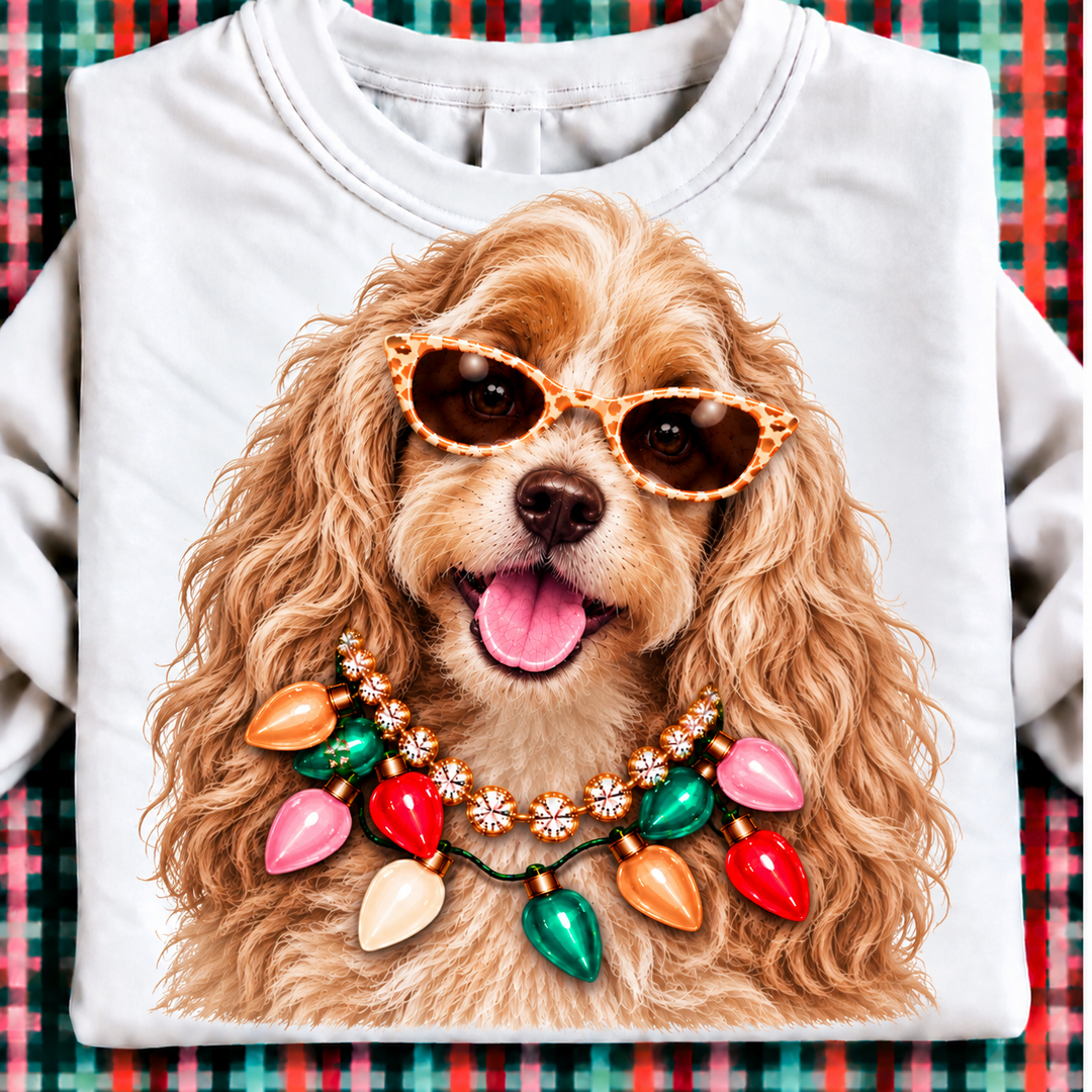 Holiday Boujee English Cocker Spaniel Christmas graphic tee or sweatshirt featuring a golden English Cocker Spaniel in statement sunglasses with a crystal necklace and Christmas lights on white