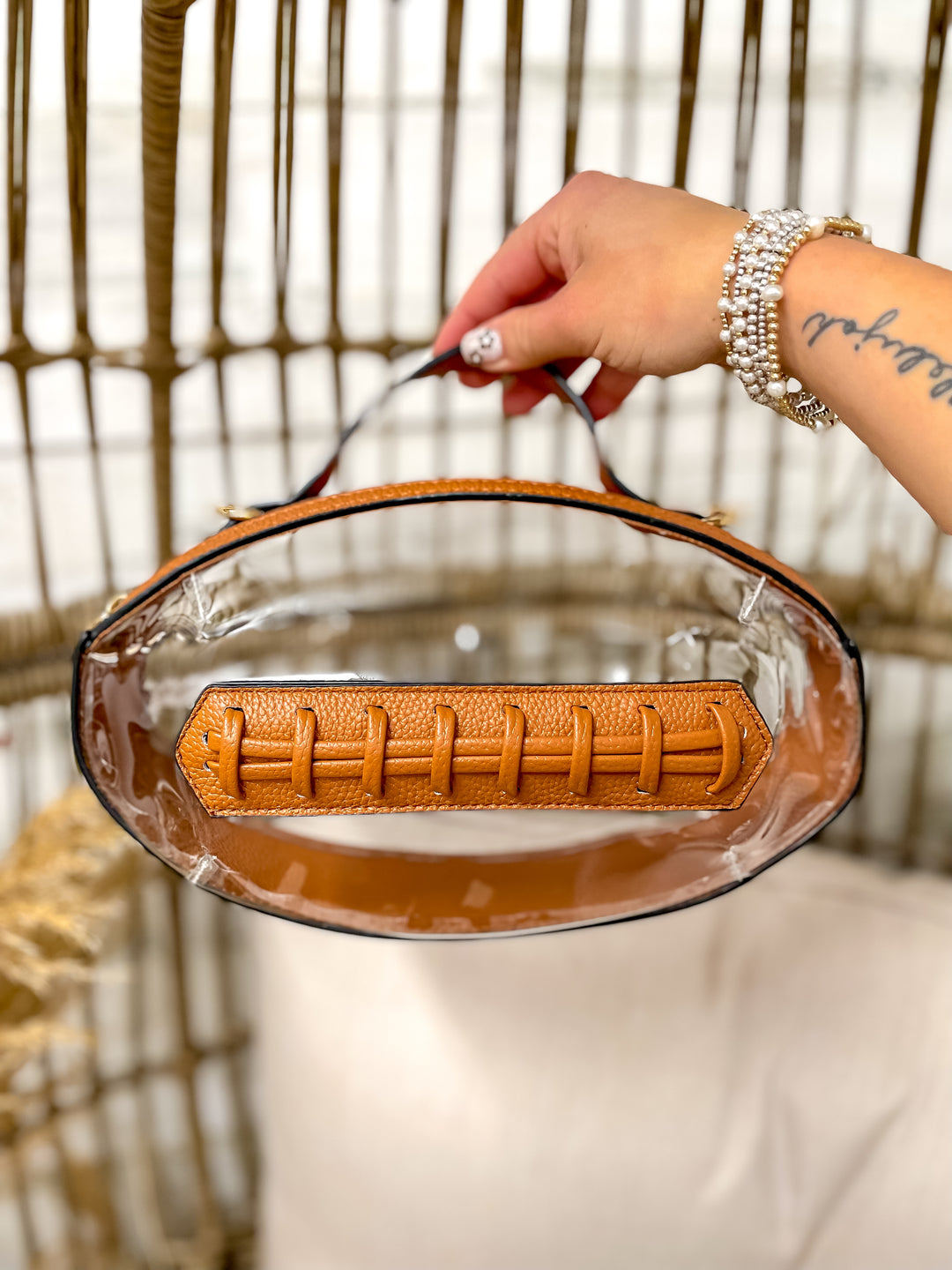 Clear football-shaped stadium bag with faux leather trim and gold hardware from Giddy Up Glamour.