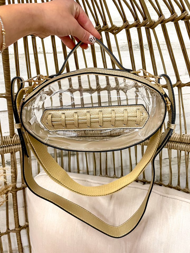 Clear football-shaped stadium bag with faux leather trim and gold hardware from Giddy Up Glamour.