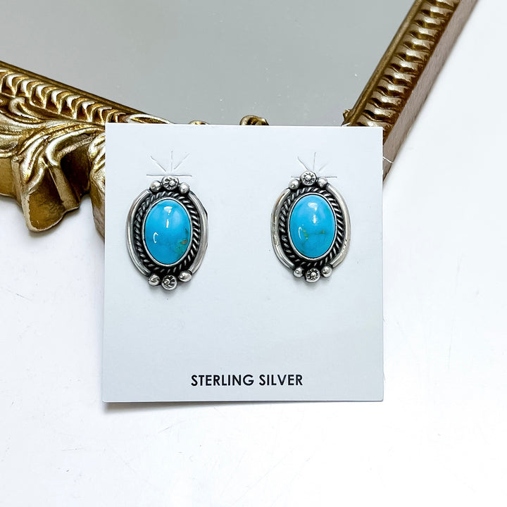 Sterling silver turquoise stud earrings handmade by Native American artist Freida Martinez with oval turquoise stones and detailed western silverwork.