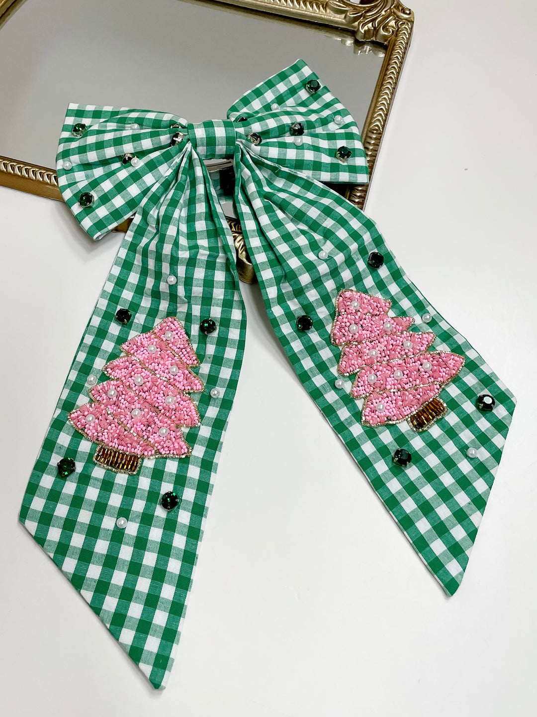 Green and white checkered bow with pink tree decorations on a white background