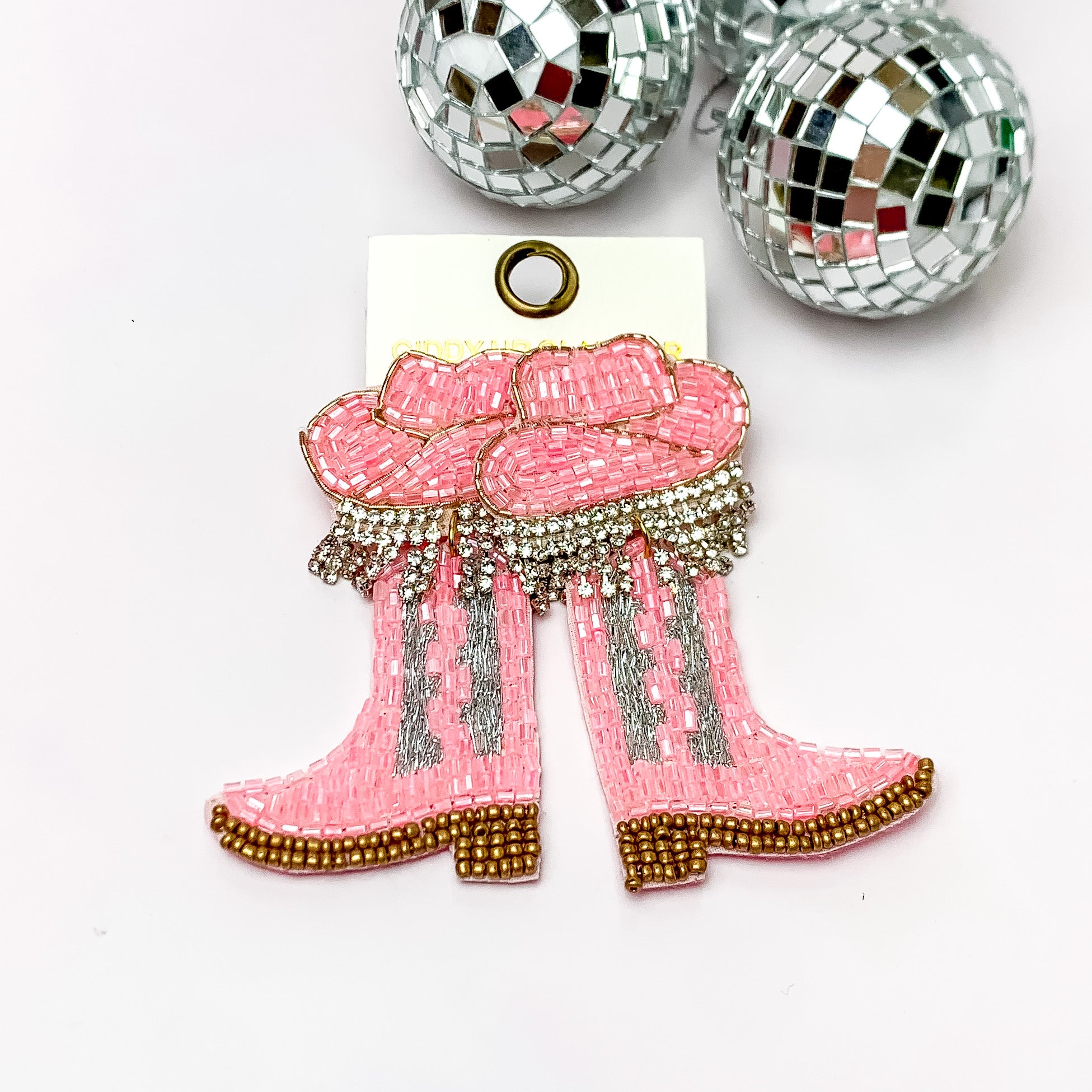 Beaded Light Pink Cowboy Boot Earrings with Hat Studs. Pictured on a white background with disco balls in the top right corner.