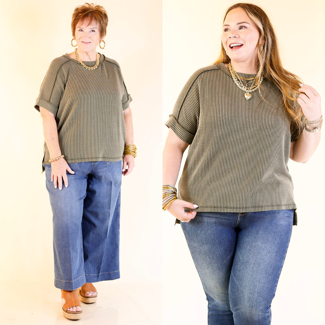 Two women wearing matching green tops and blue jeans against a plain background