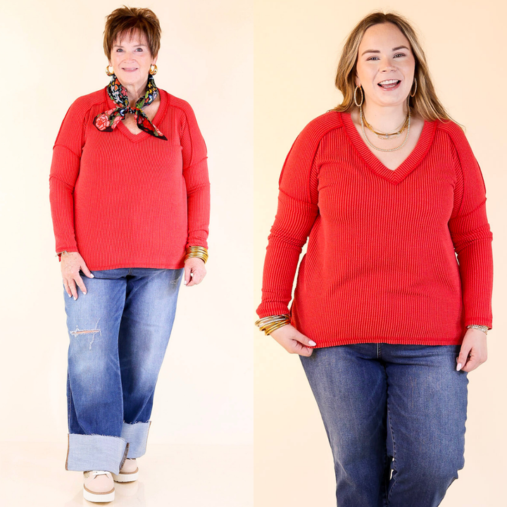 Two women wearing red tops and blue jeans on a beige background