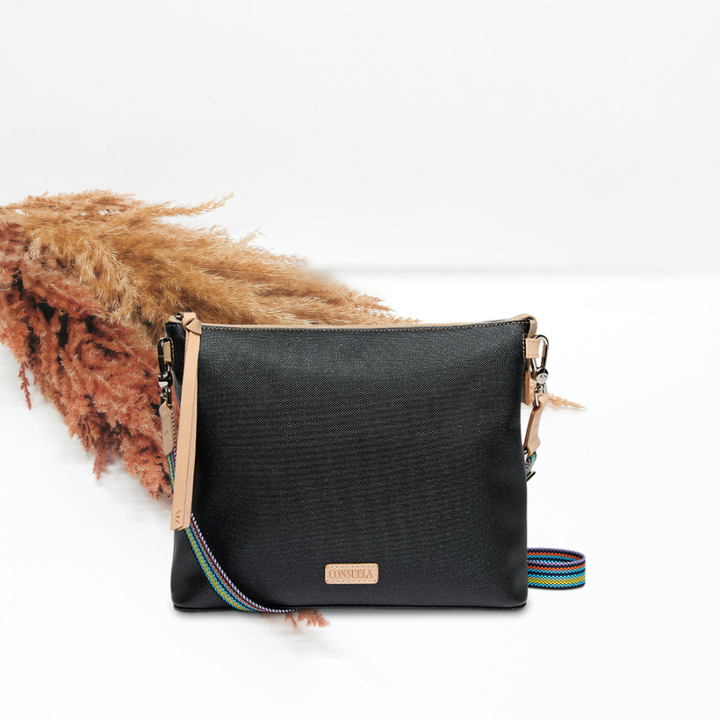 Black handbag with a colorful strap on a white background