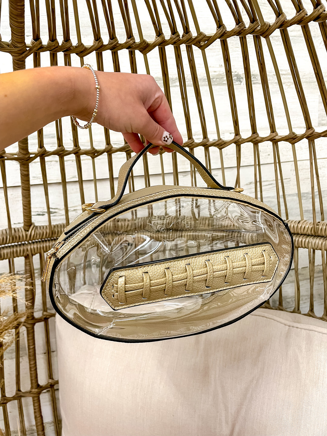 Clear football-shaped stadium bag with faux leather trim and gold hardware from Giddy Up Glamour.